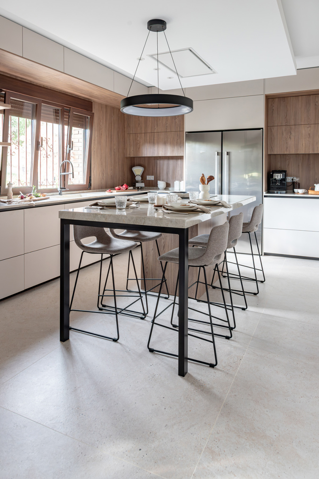 Barra con taburetes en una cocina Cashmere y nogal con isla diseñada por Santos Vaguada.