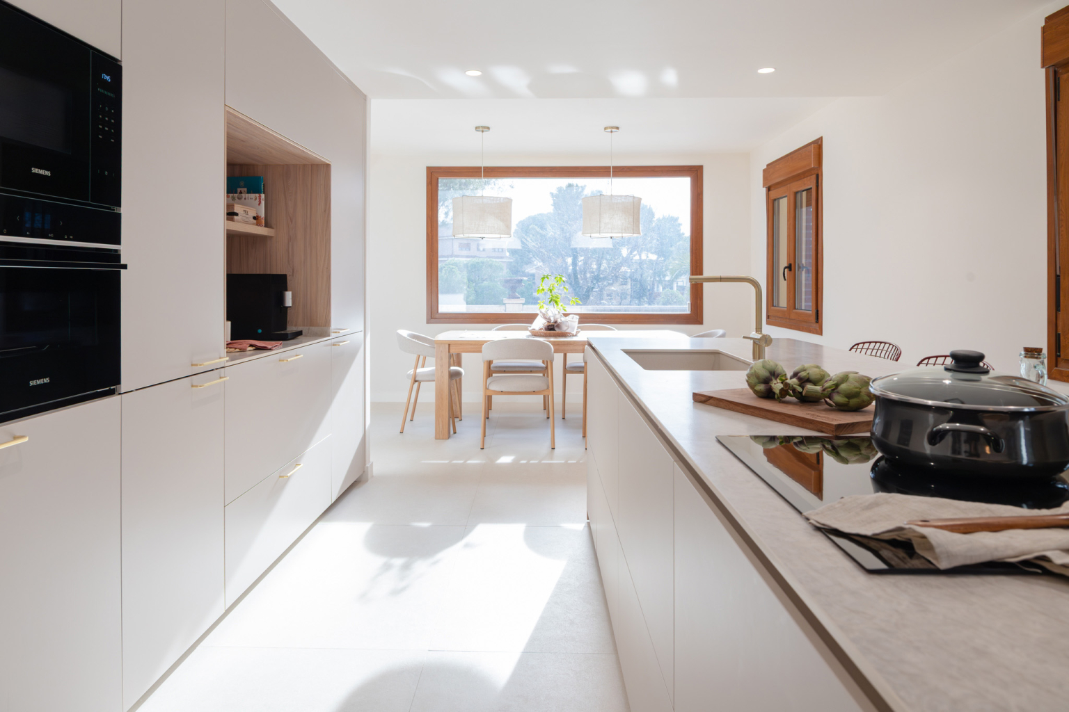 Cocina Cashmere con distribución lineal abierta al comedor diseñada por la tienda de cocinas en Madrid Santos Vaguada.