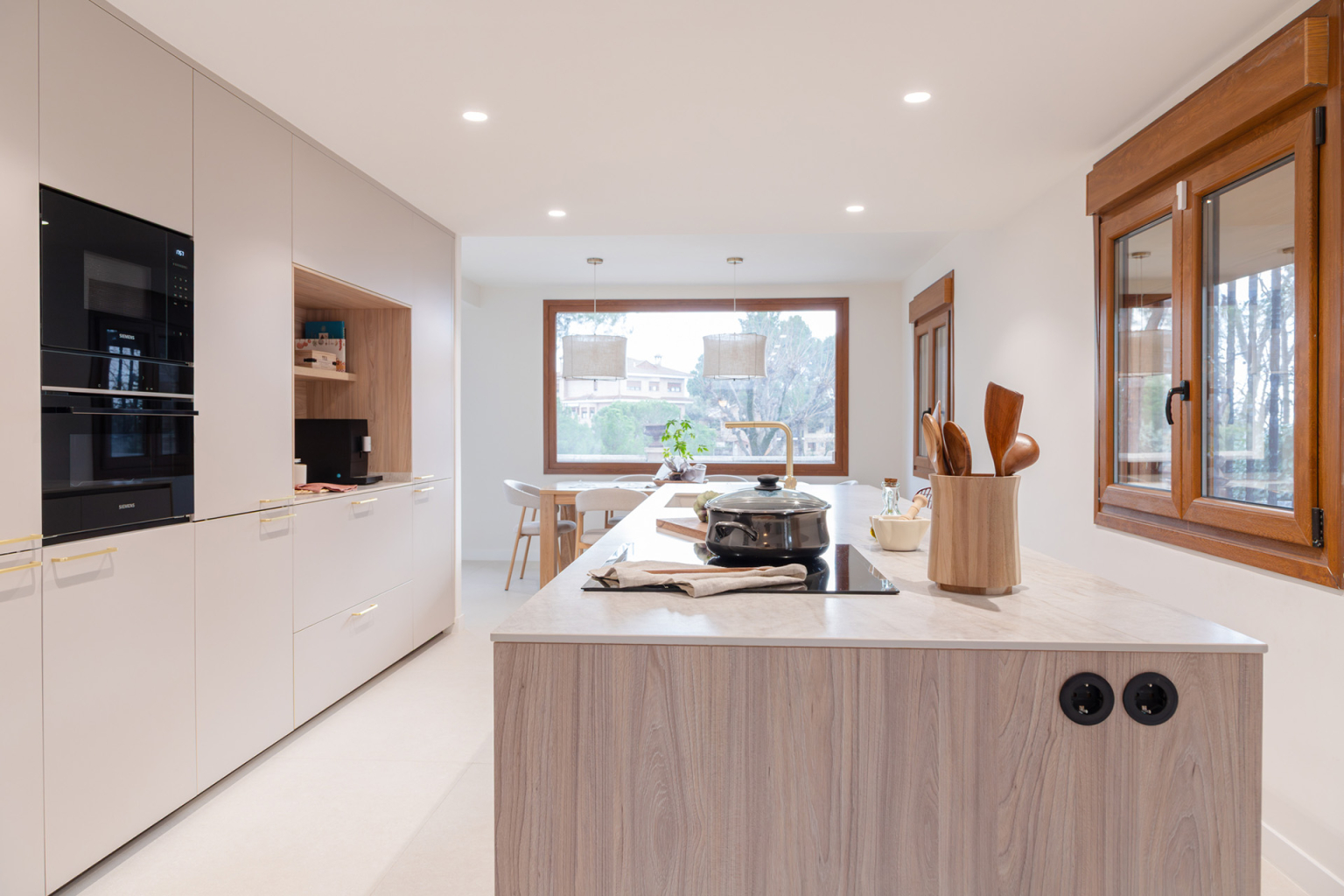 Cocina Cashmere y madera con barra en un proyecto diseñado por la tienda de cocinas en Madrid Santos Vaguada.