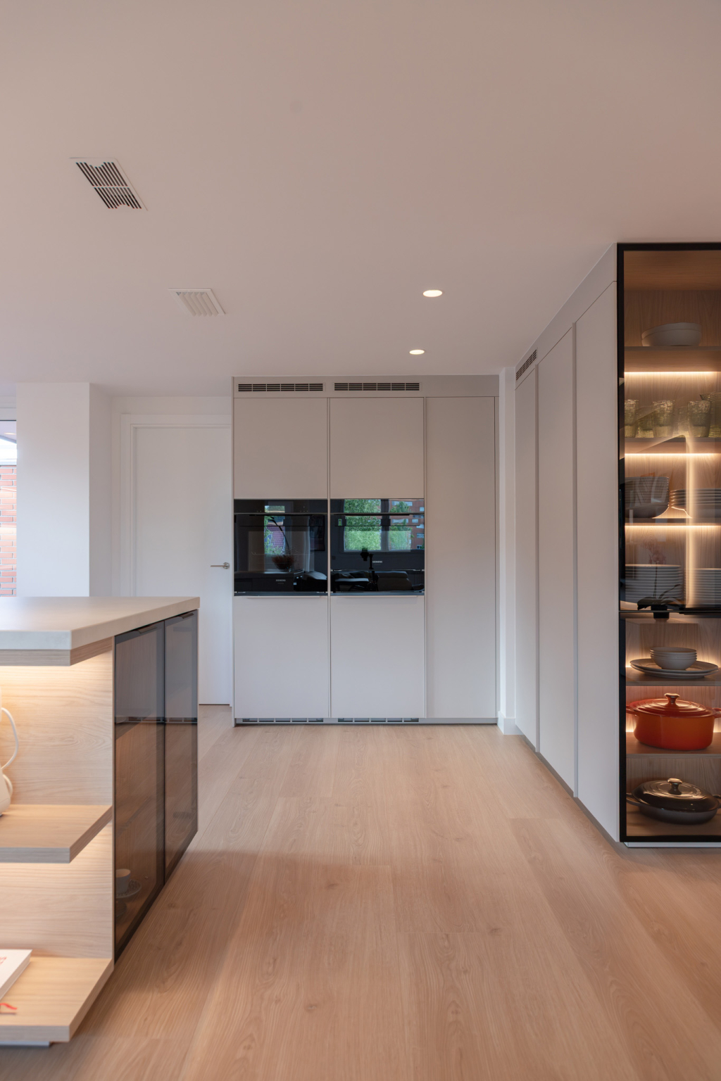Cocina Cashmere y madera con electrodomésticos en columna en un proyecto del estudio Santos Vaguada.