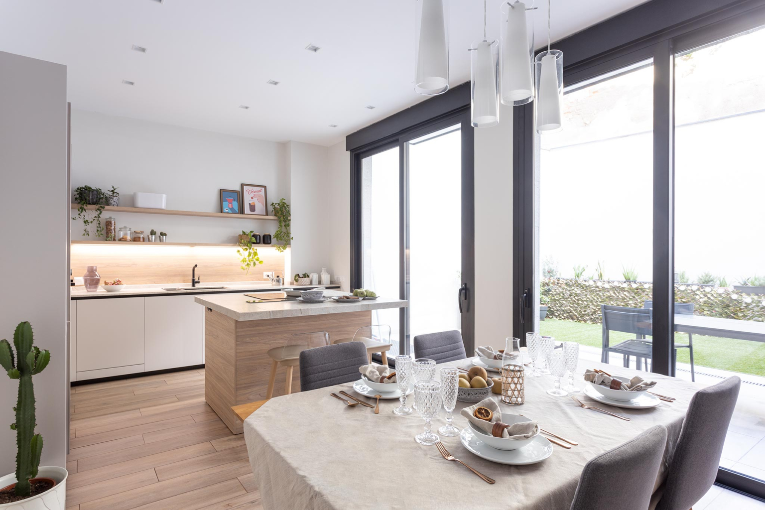 Cocina Cashmere y madera con isla abierta al comedor en un proyecto diseñado por la tienda de cocinas en Madrid Santos Vaguada.