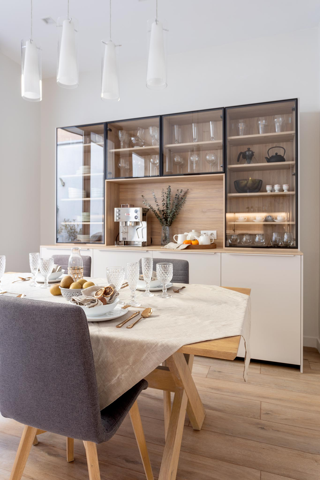 Comedor con vitrina en una vivienda con una cocina Cashmere de Santos Vaguada.