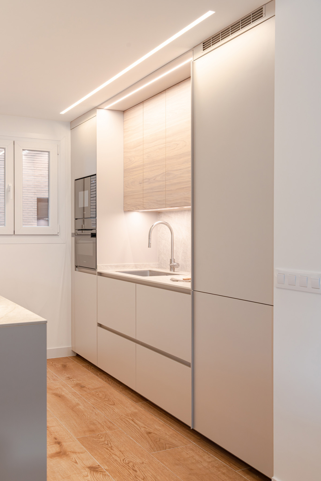 Fregadero y armarios en columna en una cocina Cashmere y madera de Santos Vaguada.