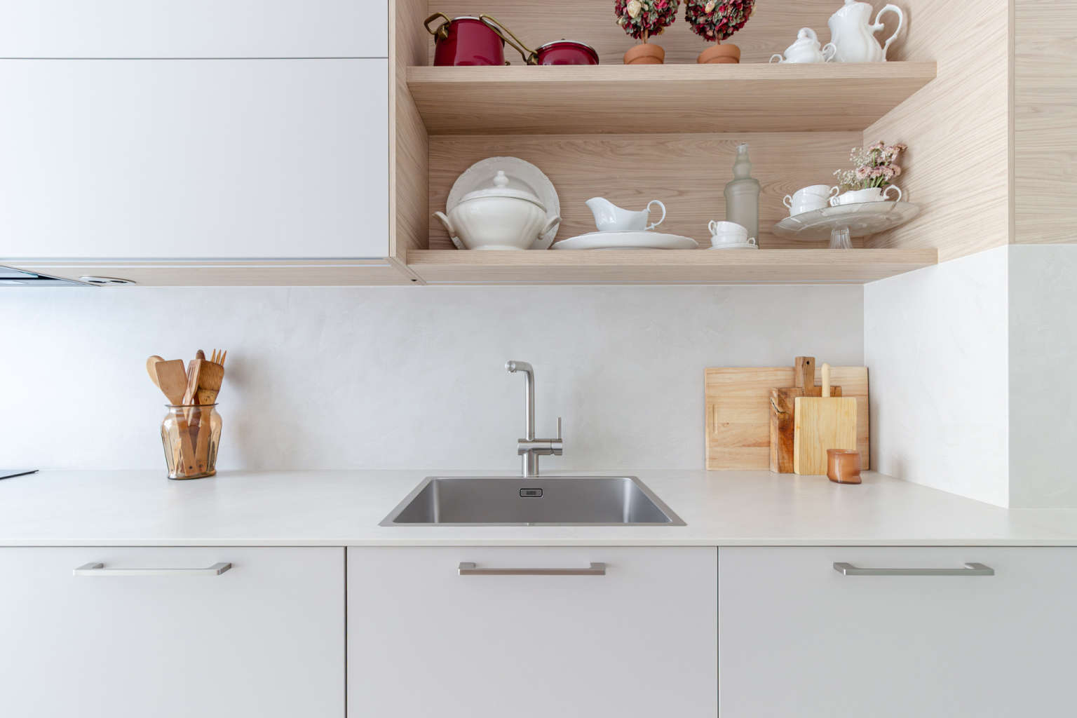 Fregadero y estantes de madera en una cocina Cashmere isla diseñada por el estudio de cocinas en Madrid Santos Vaguada.
