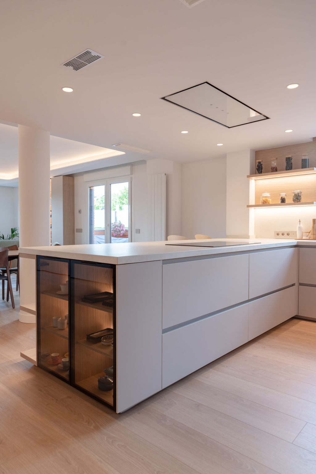 Península con vitrinas en una cocina Cashmere y madera diseñada por Santos Vaguada.
