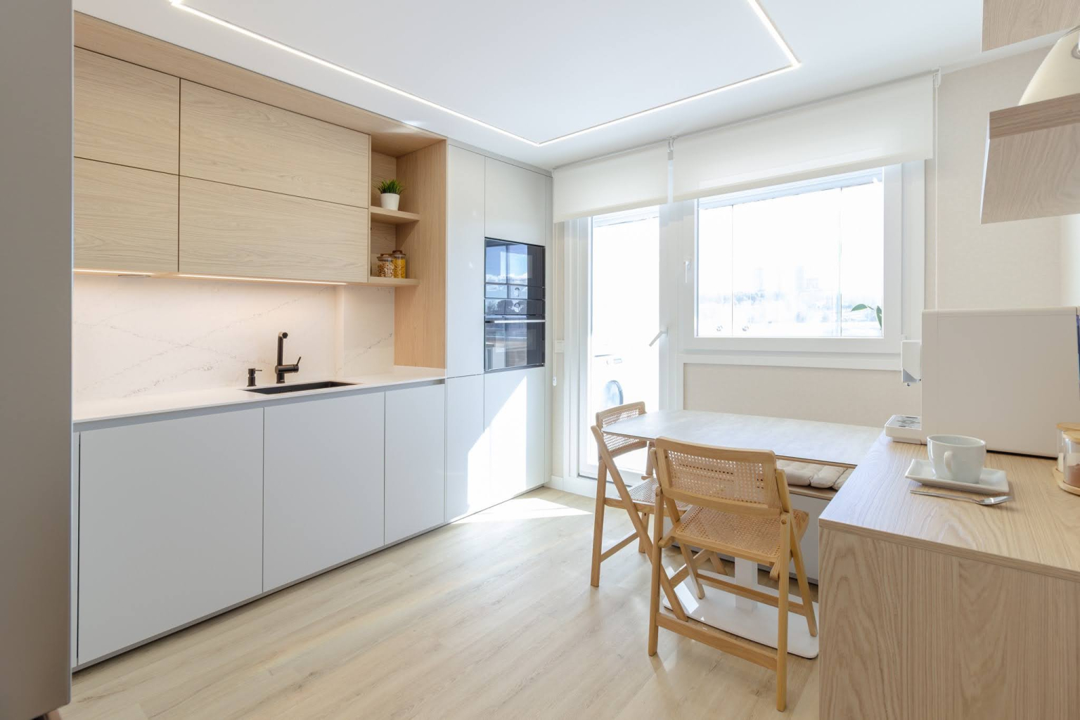 Cocina con office y barra de madera en un proyecto del estudio Santos Vaguada.