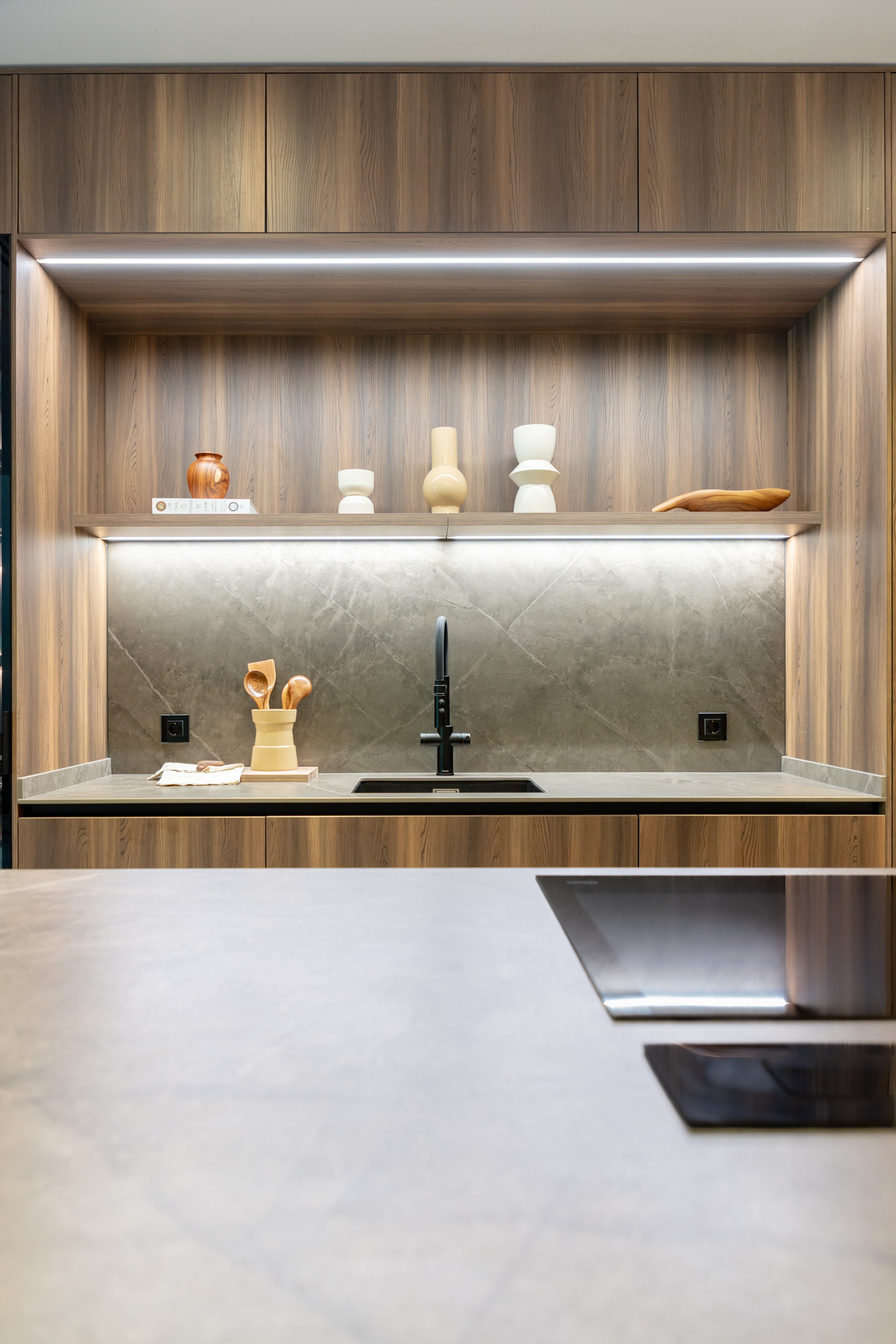 cocina con isla en madera y gris con placa de inducción y campana de encimera