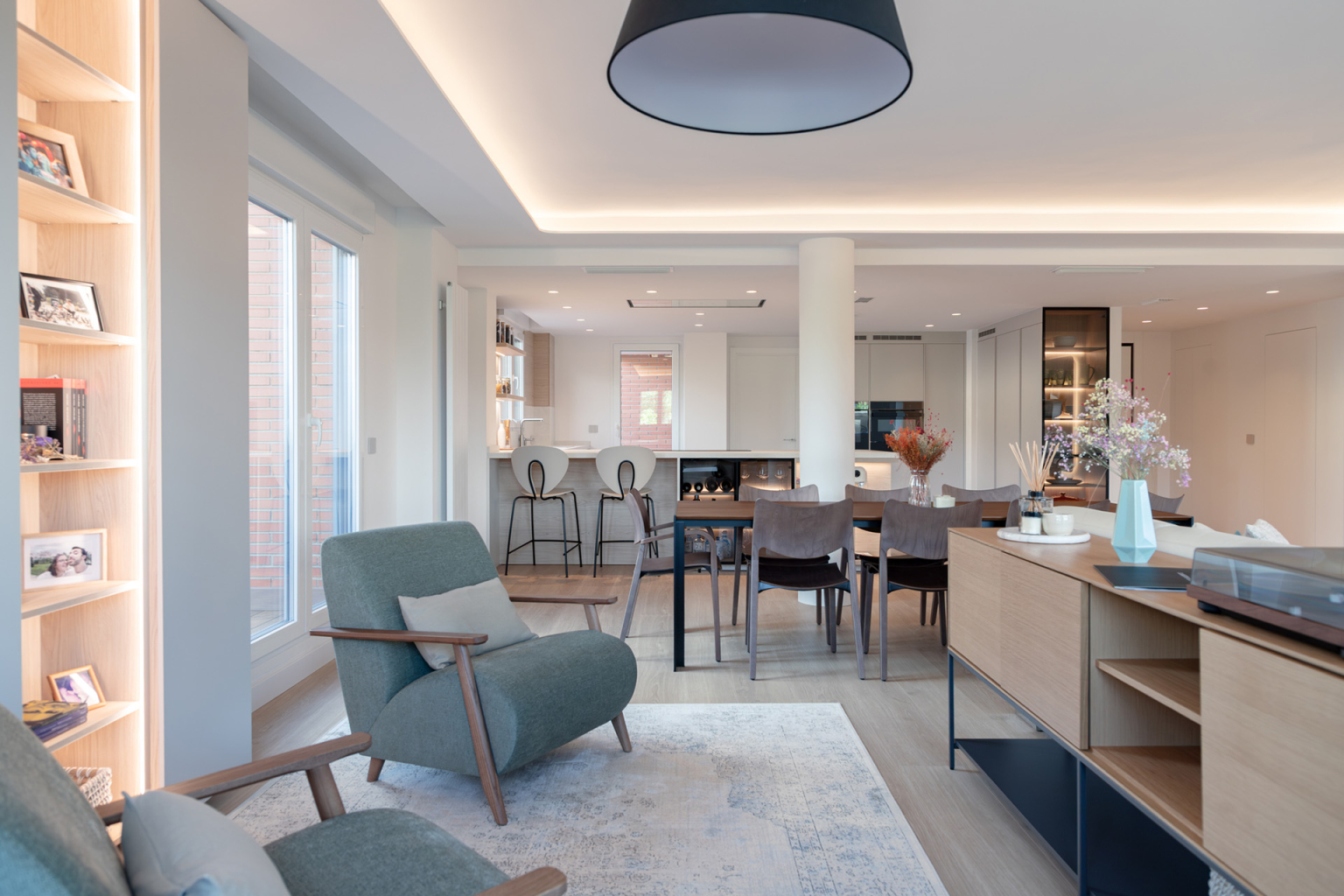 Cocina blanca con península abierta al salón diseñada por el estudio de cocinas en Madrid Santos Vaguada.