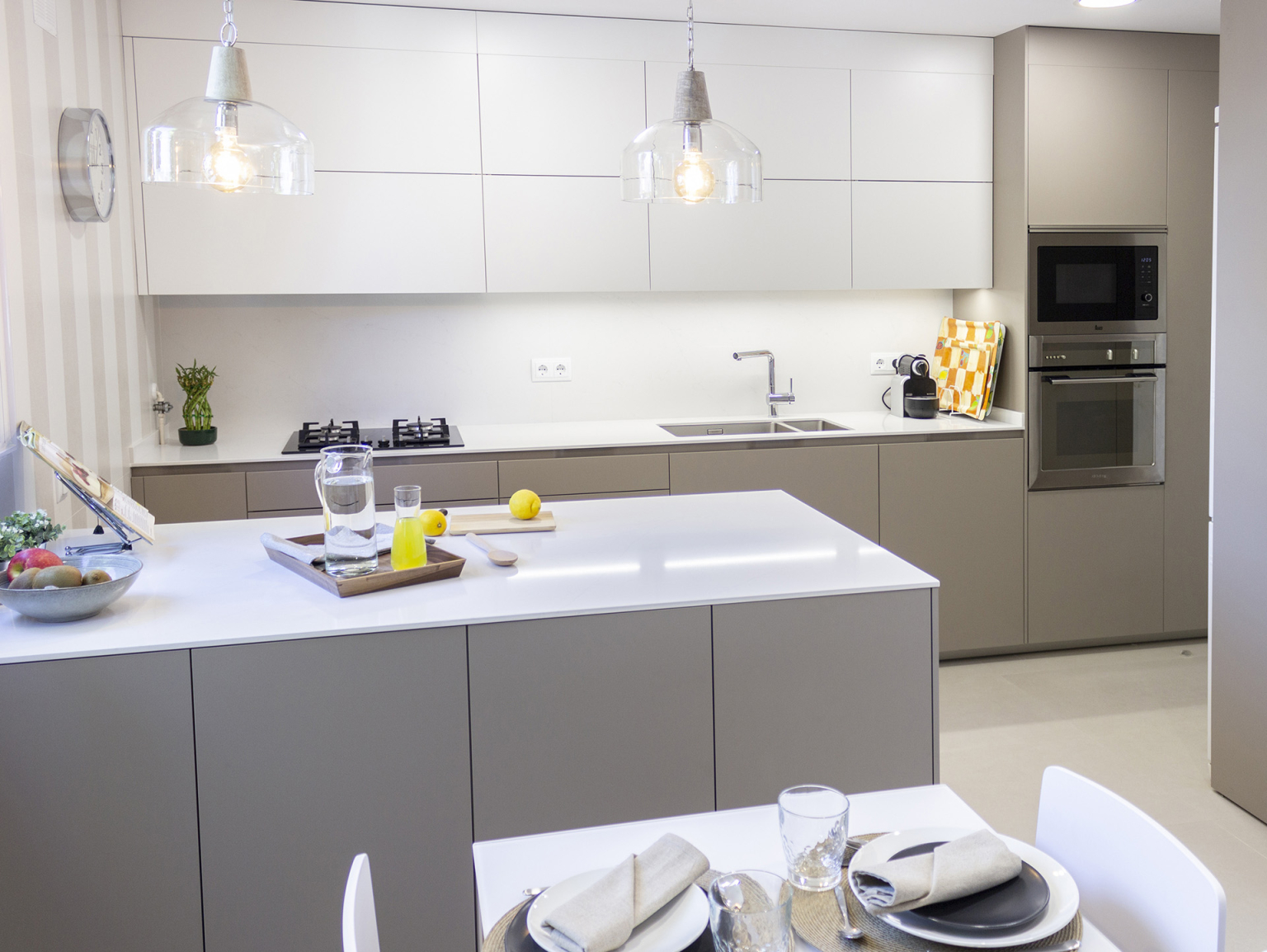 Cocina blanca y gris con península diseñada por Santos Vaguada.