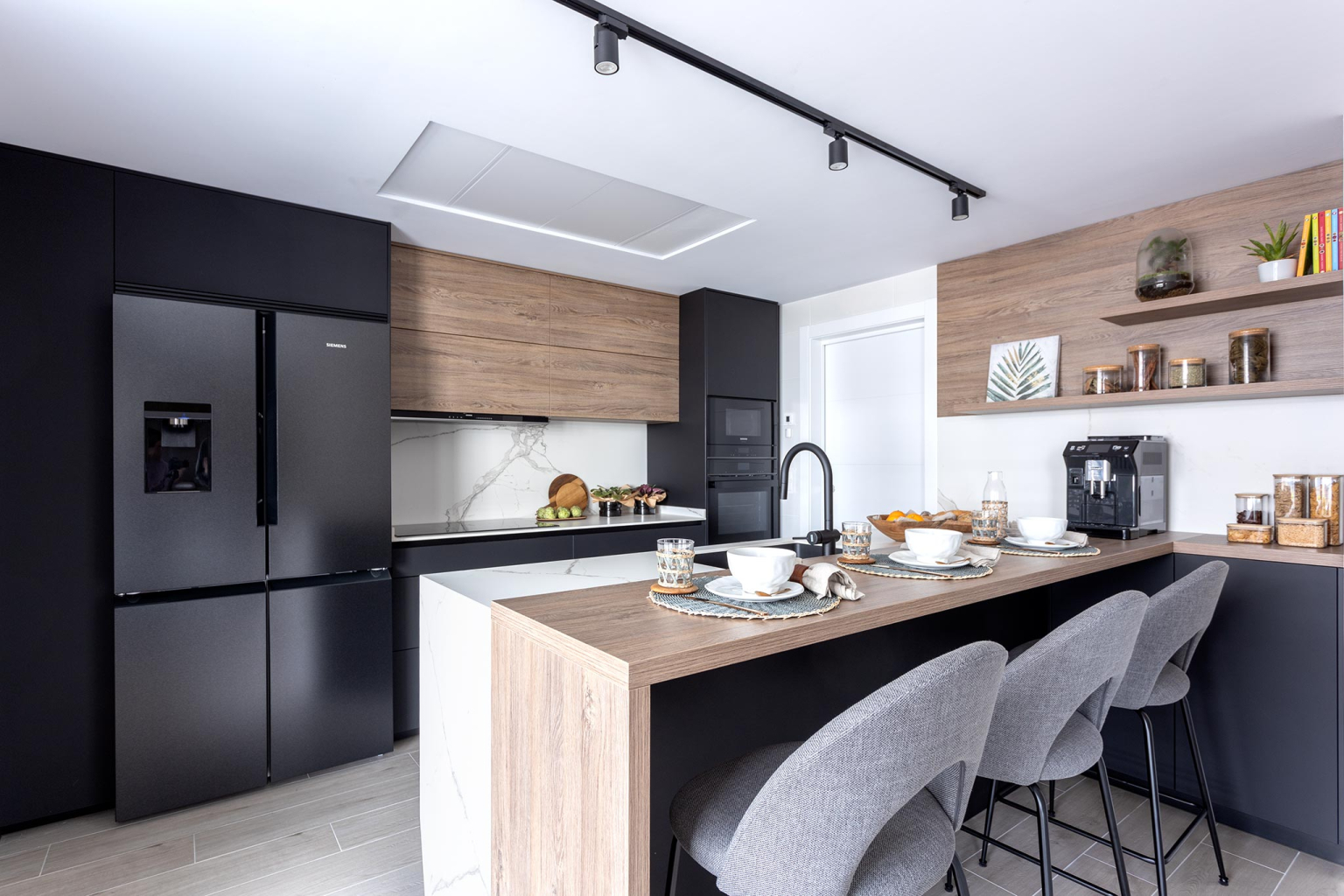 Cocina negra y madera con península en un proyecto de la tienda de cocinas en Madrid Santos Vaguada.