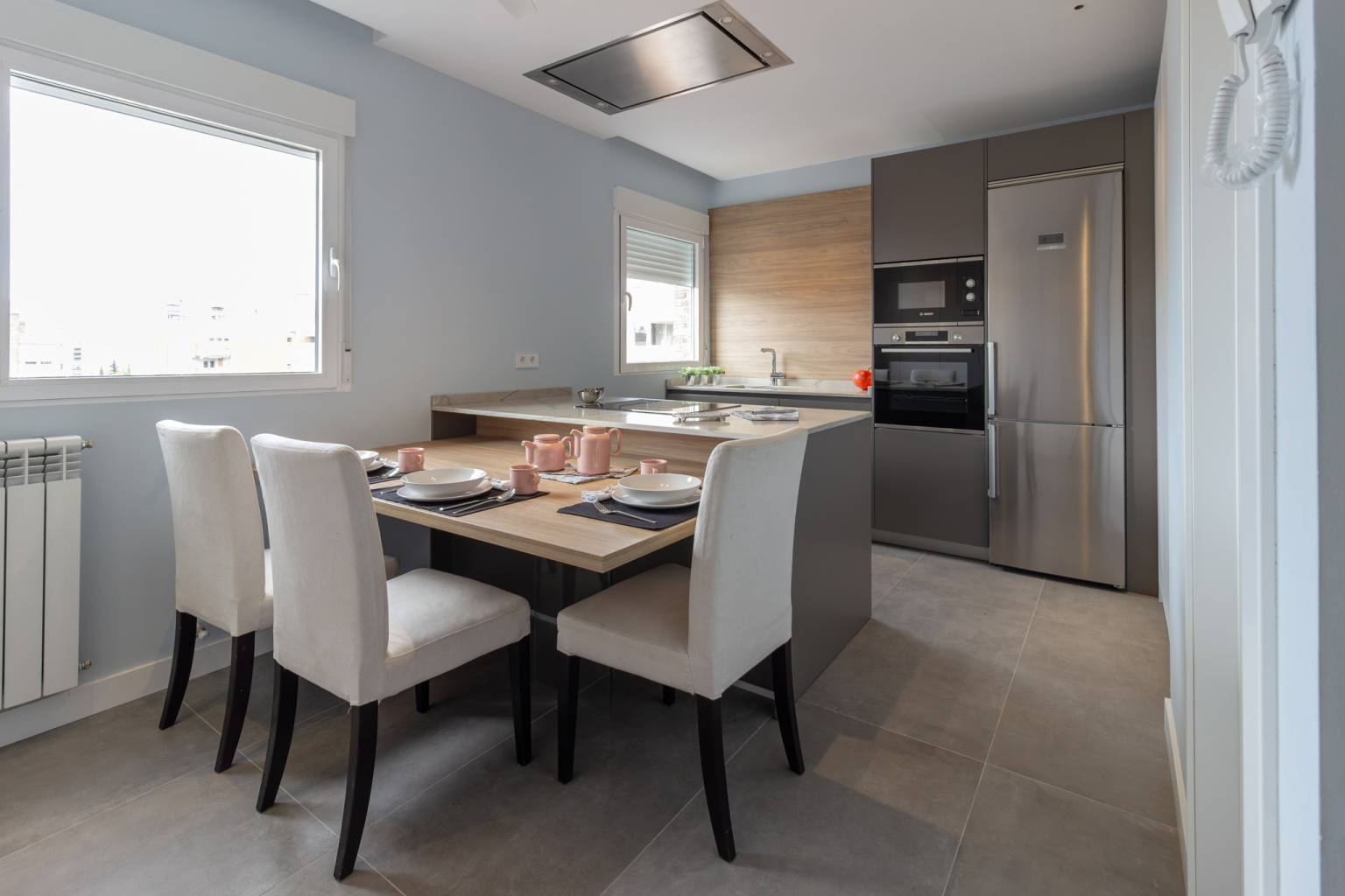 Cocina con península y mesa adosada en un proyecto de la tienda de cocinas en Madrid Santos Vaguada.