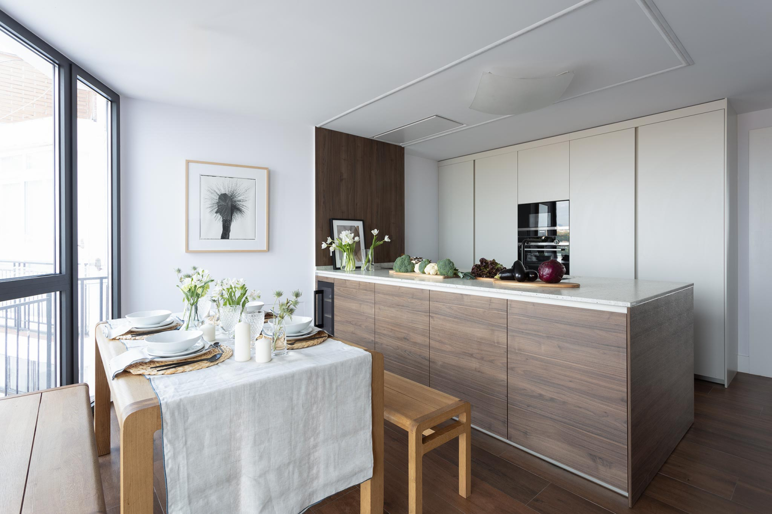 Cocina con península y mesa en un proyecto diseñado por Santos Vaguada.